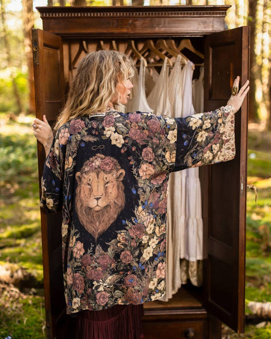Woman wearing a floral kimono with a lion design in a forest setting