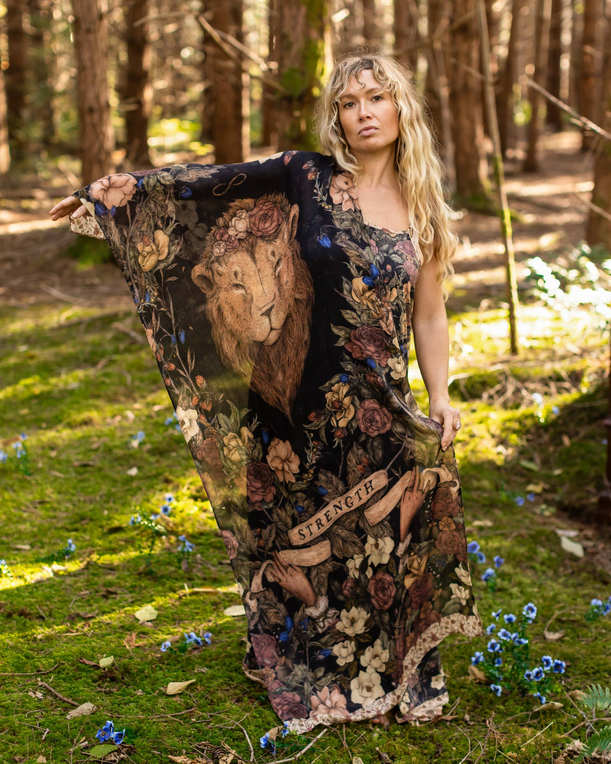 Woman in a detailed dress standing in a forest