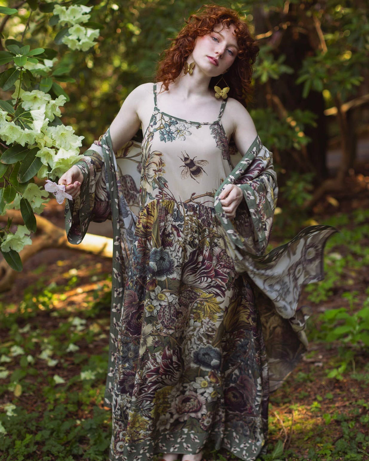 Woman in a floral dress standing in a forest setting