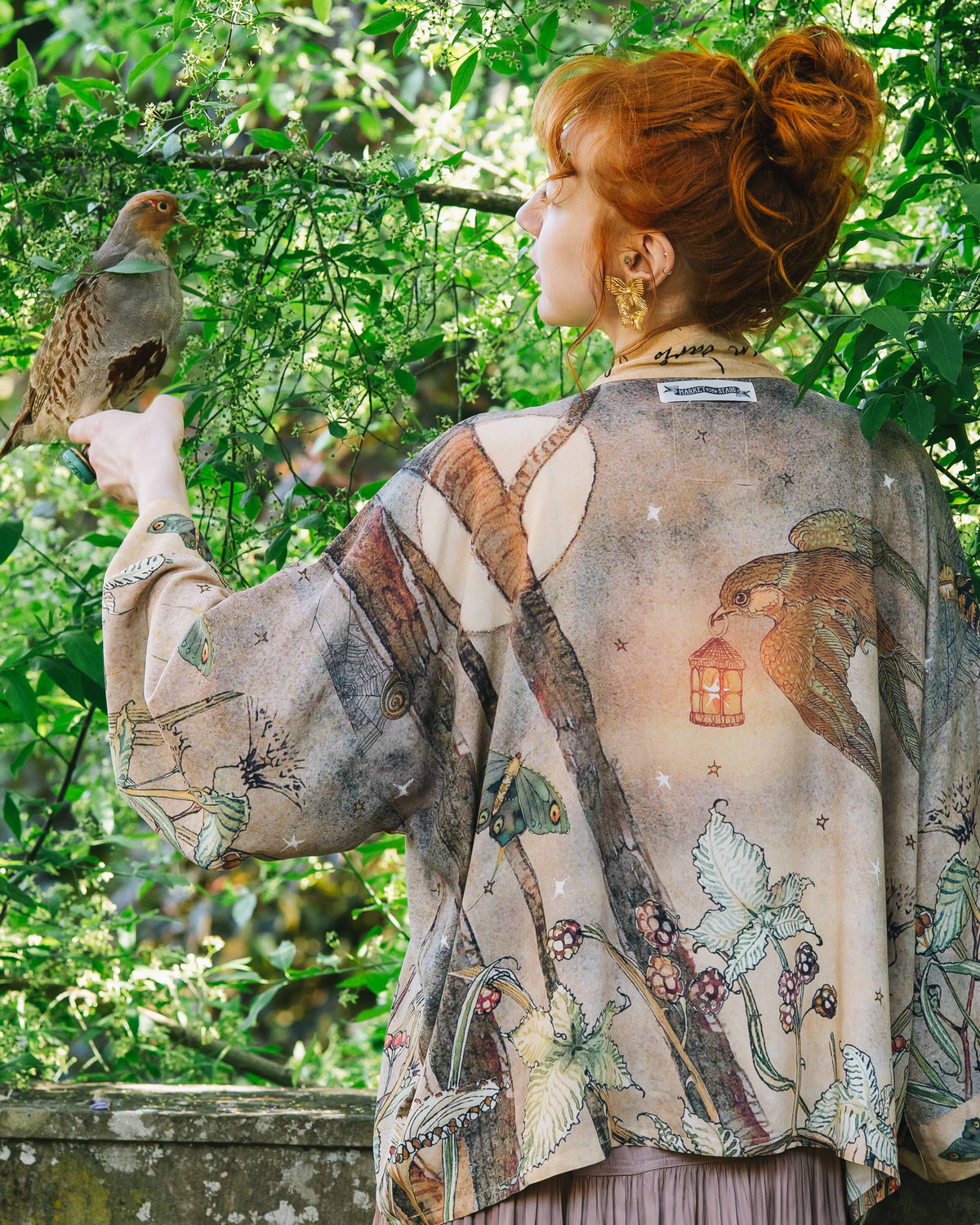Woman wearing a kimono with bird designs in a garden setting