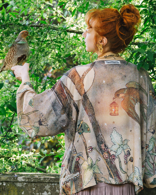 Woman wearing a kimono with bird designs in a garden setting